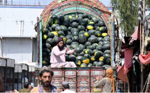 Laborers off-load a truck carrying watermelons at the Fruit and Vegetable Market.