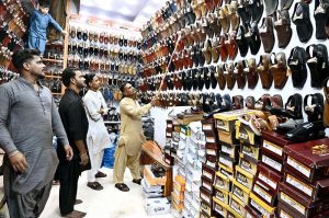 People busy purchasing ‘Peshawari Chappal’ from a vendor while preparing for the upcoming Eid-ul-Fitr at Bacha Khan Chowk.