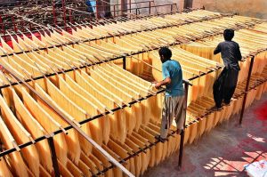 Workers hang vermicelli (seviyan) on bamboo stands for drying after preparation, as demand surges ahead of Eid-ul-Fitr at a local factory in Paretabad during the holy month of Ramazan.