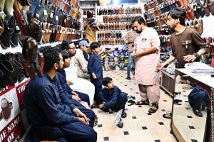 People busy purchasing ‘Peshawari Chappal’ from a vendor while preparing for the upcoming Eid-ul-Fitr at Bacha Khan Chowk.