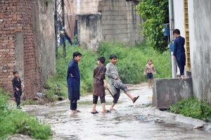 Youngsters playing in the rain water in the street after rain that experienced the Federal Capital.