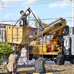 Workers are busy in repairing lights installed at center path of Double Road