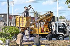 Workers are busy in repairing lights installed at center path of Double Road