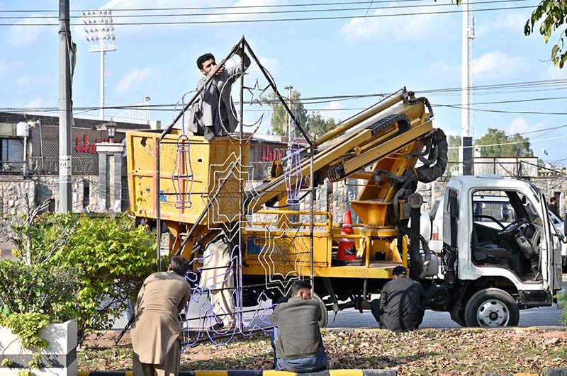 Workers are busy in repairing lights installed at center path of Double Road