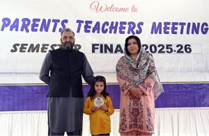 A student who secured first position in the annual examination receives a shield from the school principal during a prize distribution ceremony at Islamabad Career School Ghouri town in the Federal Capital