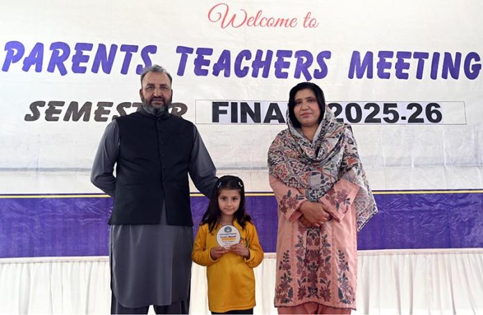 A student who secured first position in the annual examination receives a shield from the school principal during a prize distribution ceremony at Islamabad Career School Ghouri town in the Federal Capital