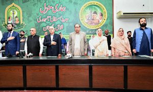 Federal Minister for Information and Broadcasting Attaullah Tarar stands during the national anthem at a ceremony marking the fourth death anniversary of former President Muhammad Rafique Tarar at Nazariya Pakistan Trust