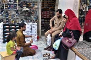 People busy purchasing ‘Peshawari Chappal’ from a vendor while preparing for the upcoming Eid-ul-Fitr at Bacha Khan Chowk.