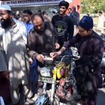 People gather at the M-Tag Registration Center to get M-Tags installed on their motorbikes in the I-9 area of the Federal Capital
