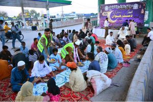 Volunteers distributing food items to deserving people to break their fast at iftar during the holy fasting month of Ramazan in Latifabad, Unit Number 07.
