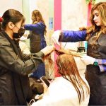 Beautician busy in applying hair color to female customer at local beauty salon in connection with upcoming Eidul Fitr