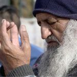 An elderly faithful offering dua after the Eidul Fitr prayer at Eidgah Sharif