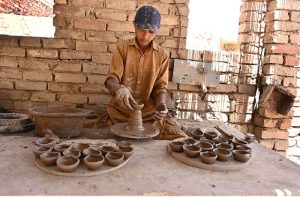A craftsman busy arranging clay-made stuff for drying purpose at his work place near Kumharpara.