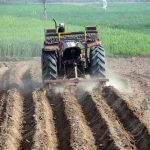 A farmer is busy preparing field with help of a tractor