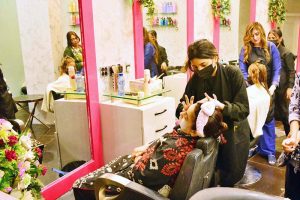 Beautician busy in applying hair color to female customer at local beauty salon in connection with upcoming Eidul Fitr