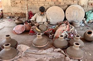 A craftsman busy arranging clay-made stuff for drying purpose at his work place near Kumharpara.