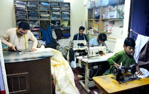 An artisan creates intricate beautiful embroidery designs on women's clothing at his workplace ahead of Eid-ul-Fitr.