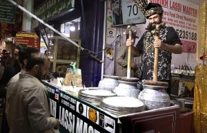 An elderly vendor prepares paan at his shop to attract customers at Banni Chowk in the city.