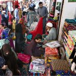 Women selecting and buying fabrics at a local cloth market