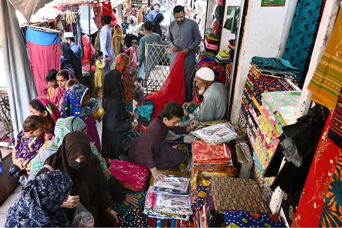 Women selecting and buying fabrics at a local cloth market