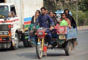 A family traveling on tricycle rickshaw towards their destination.