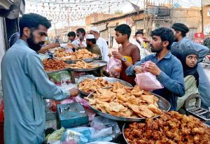 Customers purchase samosas and pakoras from a roadside stall for Iftar to break their fast during the holy month of Ramazan. APP/HBR/BWP/MAF/TZD/SSH
