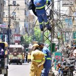 HESCO workers repair a wire on a pole at Haider Chowk to restore power supply in the area