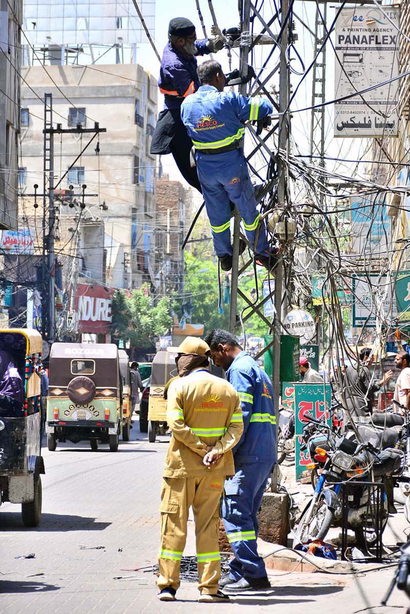 HESCO workers repair a wire on a pole at Haider Chowk to restore power supply in the area
