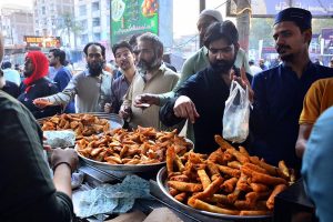 People busy purchasing traditional food items for iftar from a vendor stall at Latifabad Unit 11 during the holy month of Ramazan