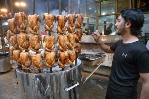 A vendor prepares the traditional food item Sajji to attract customers during the holy month of Ramazan at Food Street in the provincial capital.