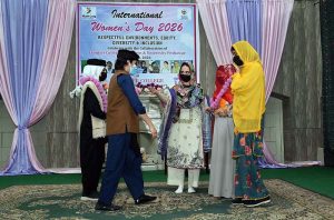 Female students presenting tableau on stage during International Women's Day organized by Hum Log at Govt. Frontier College for Women