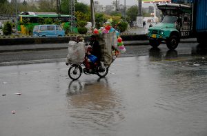 Vehicles passing through the stagnant water at IJP Road during rain in the Federal Capital.
