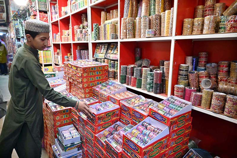 A young vendor displaying colorful bangles to attract the customers at G-9 Market in connection with Eidul Fitr