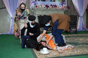 Female students presenting tableau on stage during International Women's Day organized by Hum Log at Govt. Frontier College for Women