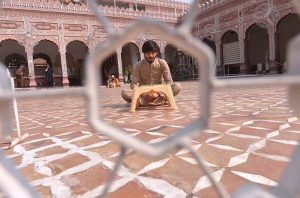 A person reciting the Holy Quran after prayer during the Holy fasting month of Ramazan at Sunehri Masjid.