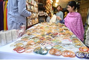 A girl purchasing bangles from a shop in preparation of Eid ul Fitr celebrations. APP/SMR/ABB