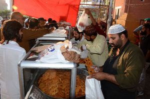 Customers are crowd on stall to buy Jalebi and other snacks from shopkeeper ahead of iftar during holy month of Ramazan.