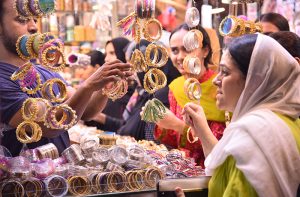 Women purchasing bangles and jewelries during Eid shopping at Hyderi Market.