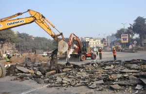 Workers are demolishing the road with heavy machinery near Data Darbar.