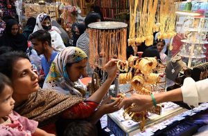 Women busy purchasing bangles and artificial jewelry during shopping at Resham Gali in preparation for the upcoming Eid-ul-Fitr.