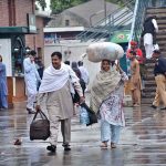 A couple arrives at the railway station with their luggage to leave for their hometown and celebrate Eid-ul-Fitr with their loved ones