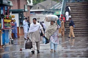 A couple arrives at the railway station with their luggage to leave for their hometown and celebrate Eid-ul-Fitr with their loved ones