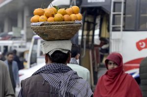 A splash of orange in a life painted with struggle, a street hawker carrying more than oranges—he carries hope and a family’s future.