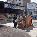 Labourers clean and sort canola seeds at the grain market in the city.