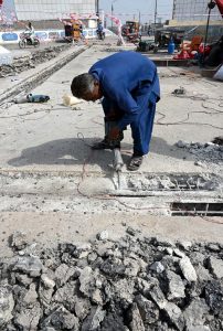 A labourer carries out repair work on a railway over bridge road.
