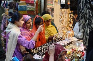 Women busy purchasing bangles and artificial jewelry during shopping at Resham Gali in preparation for the upcoming Eid-ul-Fitr.