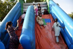 Children enjoy swings at a local park, filling the area with laughter and energy.