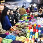 Women busy selecting and purchasing bangles from a stall at Jinnah Super Market ahead of Eid-ul-Fitr in the Federal Capital