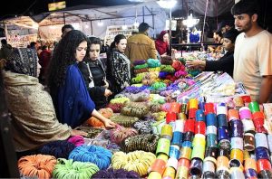 Women busy selecting and purchasing bangles from a stall at Jinnah Super Market ahead of Eid-ul-Fitr in the Federal Capital