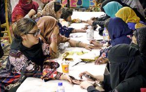 A girl being decorated her hand with Hinna (Mehndi) during the Eid Free Bazaar “Maa Hum Bhi Eid Manyen Gay” organized by JDC Welfare Foundation